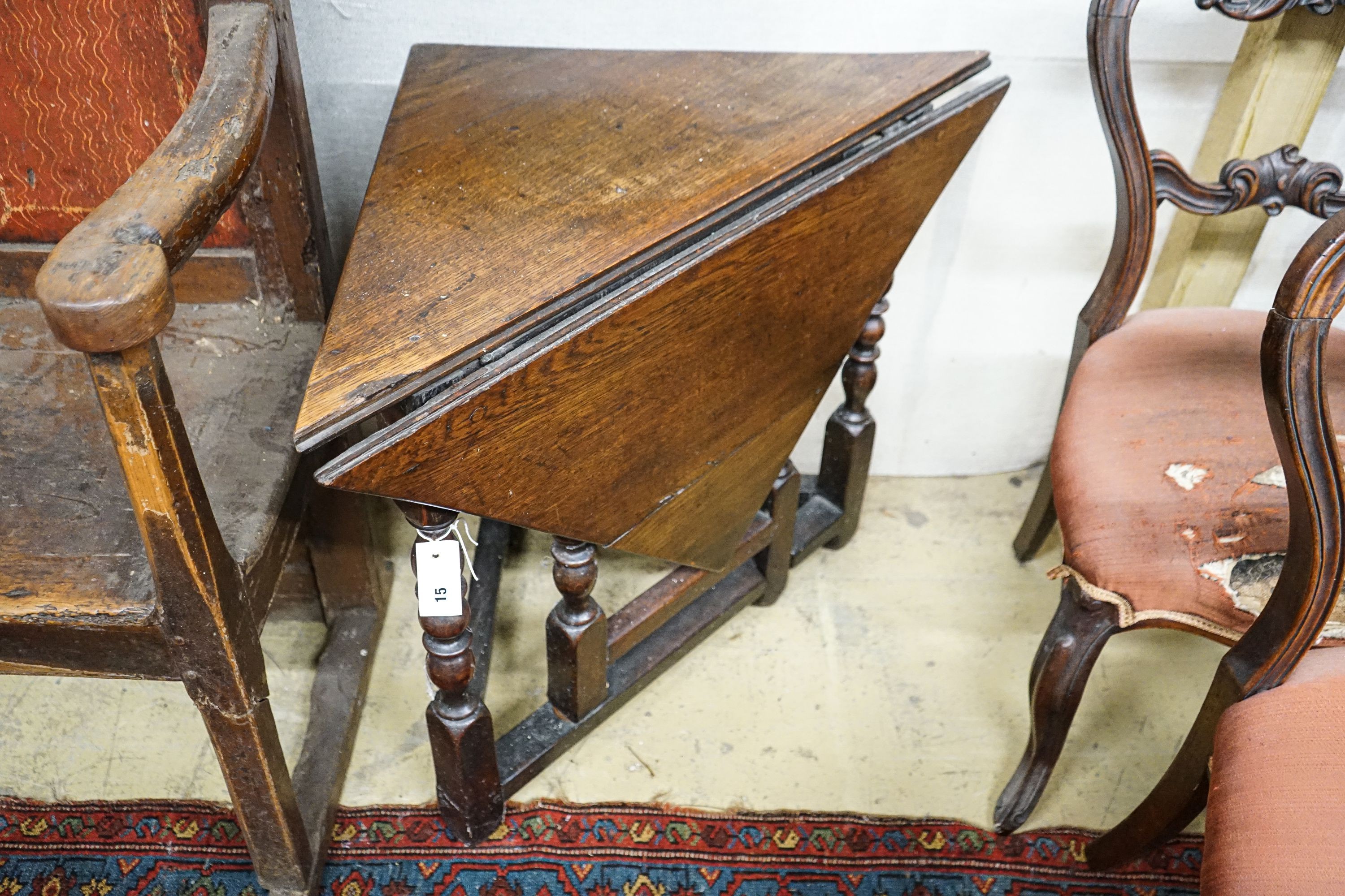 An early 18th century oak drop leaf table, with triangular flap and turned gateleg action underframe, width 62cm, depth 62cm, height 68cm